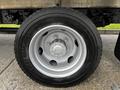 A close-up view of a silver wheel with six bolts and a black tire labeled with the brand name and specification on the sidewall