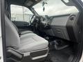 Interior of a 2015 Ford F-550 showing two gray seats and a dashboard displaying controls and a steering wheel