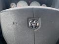 Close-up of a Dodge Ram 5500 steering wheel featuring a prominent chrome Ram logo at the center with a textured gray surface