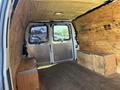 Interior view of a 2012 Chevrolet Express cargo van showing a wooden floor and built-in storage boxes on either side