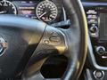 Close-up of the steering wheel of a 2021 Nissan Murano showing buttons for cruise control and other functions with a leather cover