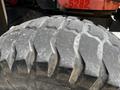 Close-up of a worn tire from a 2011 Kubota M8540D showing deep treads and visible dirt and wear on the rubber surface