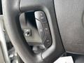 Close-up of the steering wheel of a 2020 Chevrolet Express showing control buttons for cruise control and other functions
