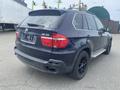 A 2009 BMW X5 in black with a sporty design featuring dark wheels and a rear spoiler without a license plate