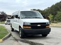 A 2021 Chevrolet Express van in white with a black grille and chrome accents parked on a street