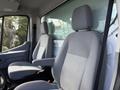 Interior of a 2016 Ford Transit showing two gray cloth seats with armrests and a spacious cabin design