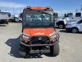 A 2018 Kubota ATV with an orange body and black accents featuring a protective front bumper and a windshield showing the vehicle's front view