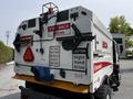 A 2012 Autocar Xpert truck with various warning signs and symbols on the back including caution signs and instructions related to visibility and safety
