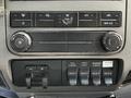 The dashboard controls of a 2016 Ford F-550 featuring air conditioning buttons auxiliary switches and lighting controls