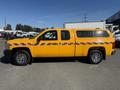 A yellow 2013 Chevrolet Silverado 1500 pickup truck with a matching canopy and decorative red and white stripes on the side