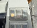 Three control buttons on a piece of machinery with icons for up, stop, and down functions