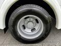Close-up of a Chevrolet Express wheel featuring a silver rim and a Bridgestone tire with tread pattern visible