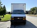 A 2024 Chevrolet Express with a black grille and a silver body facing forward