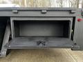 A 2008 International 7500 truck with an open storage compartment featuring a black metal door and latch mechanism