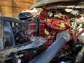 Close-up of the engine compartment of a 2016 Freightliner M2 106 showing various red and black components and hoses.
