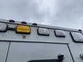 A 2014 Chevrolet Express van with a view of the roof showing various lights including a yellow warning light and several clear lights