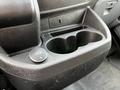 Close-up of the center console in a 2018 Ford Transit featuring a 12V power outlet and a cup holder design