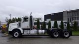 A 2019 Western Star Trucks 4900 in a side view showing its distinct long hood and large wheels with a white exterior and chrome details