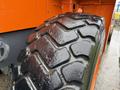 Close-up of a large, rugged tire from a 2018 Doosan DL300-5 construction vehicle showcasing deep tread patterns and a sturdy rubber surface