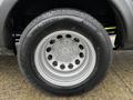 A close-up view of a silver wheel from a 2021 Ford Transit featuring a tire with the size 205/75R16C and multiple circular holes in the wheel design