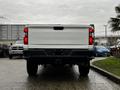 A 2021 Chevrolet Silverado 3500HD viewed from the rear showing its tailgate and bumper with a white finish