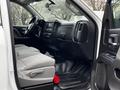 Interior of a 2018 GMC Sierra 1500 featuring a driver seat with gray upholstery and a black dashboard with various controls and steering wheel in view