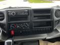 Dashboard of a 2013 Hino 195 featuring a radio control panel air conditioning knobs and multiple storage compartments