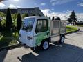 A 2019 CanEV Might-E Truck with a compact design featuring a green and white color scheme and a mesh cargo bed