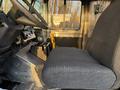 The interior of a 2017 Freightliner M Line featuring a driver's seat made of black fabric with a textured surface and a dashboard with various controls and instruments