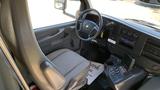 Interior view of a 2011 Chevrolet Express with a driver's seat and dashboard featuring controls and a stereo system