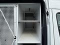 A 2012 Mercedes-Benz Sprinter with an open cargo area featuring a steel grate and a metal shelf inside