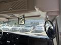 2017 Chevrolet Express interior showing dashboard controls and mirror with a view of parked cars in the background
