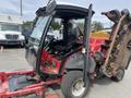 A 2012 Toro Groundsmaster 5910 lawn mower featuring a red and black cab with a single seat steering wheel and an attached mowing deck on one side