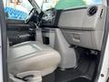 Interior view of a 2009 Ford Econoline showing the driver's seat dashboard and center console with controls and storage compartments