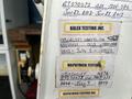 A 2006 Ford Econoline with various inspection and testing stickers attached to its body