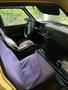 Interior view of a 1978 Volvo 244 showing the driver's seat with a purple cover and a dashboard featuring vintage controls and a steering wheel
