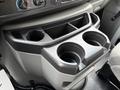 Interior view of a 2022 Ford Econoline console featuring dual cup holders and control knobs
