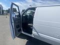 A 2009 Ford Econoline van with the driver's side door open and the interior partially visible showing the driver's seat and dashboard