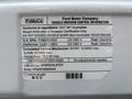 A 2017 Ford Econoline with a vehicle emission control information label showing regulatory details and specifications