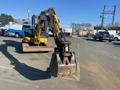 A yellow and black 2006 Komatsu PC55MR2 mini excavator with a digging bucket in the foreground