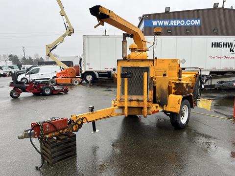 A 1993 Bandit 200 wood chipper with a bright yellow exterior featuring a large chute and a mechanical feed intake on a trailer with wheels