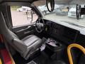 Interior of a 2015 Chevrolet Express with a driver's seat, dashboard controls, steering wheel, and gear shift visible