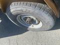 Close-up of a rugged tire mounted on a wheel with a visible hub featuring several bolt holes and a textured tread pattern labeled Radial 4x4
