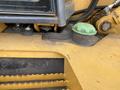 Close-up of a 2012 John Deere 310SJ machinery component showcasing a green cap and rugged surface details of the equipment