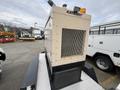 A 2005 Trailerman Generator Trailer with a beige exterior and grid-like ventilation on the front, equipped with a warning light on top
