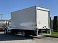 A 2017 Freightliner M2 106 box truck with a white cargo area and a loading dock at the rear