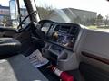 The interior of a 2016 Freightliner M2 106 showing the dashboard controls seat and steering wheel