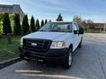 A white 2008 Ford F-150 XL pickup truck is parked with its door open showing the interior and features a black grille with the Ford logo