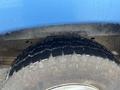 Close-up of a tire from a 2006 Ford Econoline showing treads and water droplets on the surface
