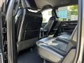 Interior of a 2022 RAM 3500 showing black leather seats in the back row with a central armrest and cupholders